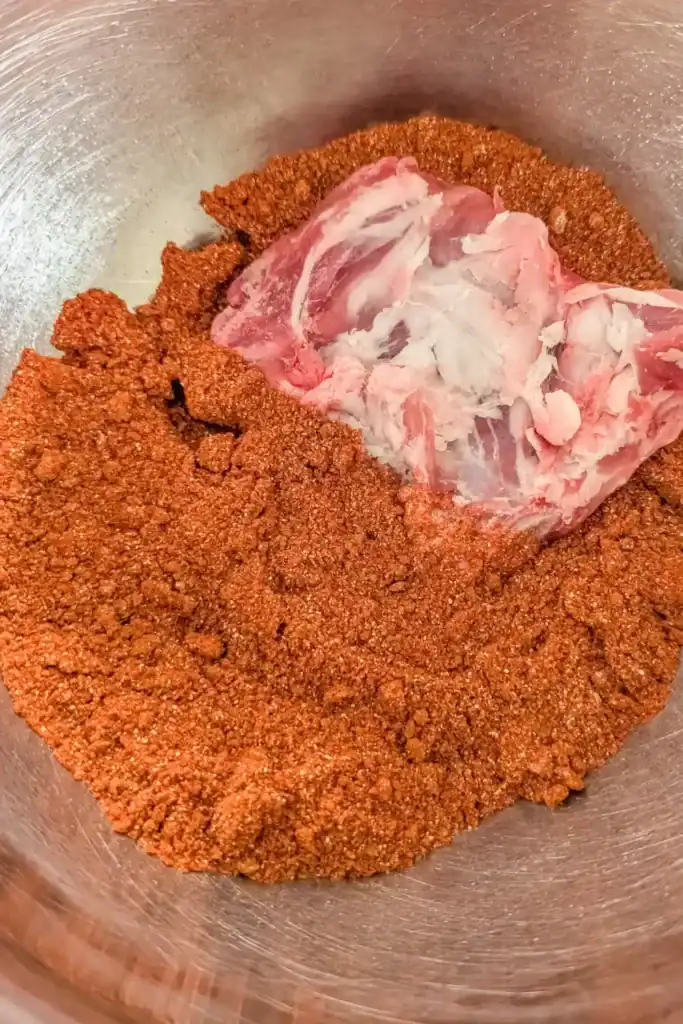 adding pork section to the dry rub to coat