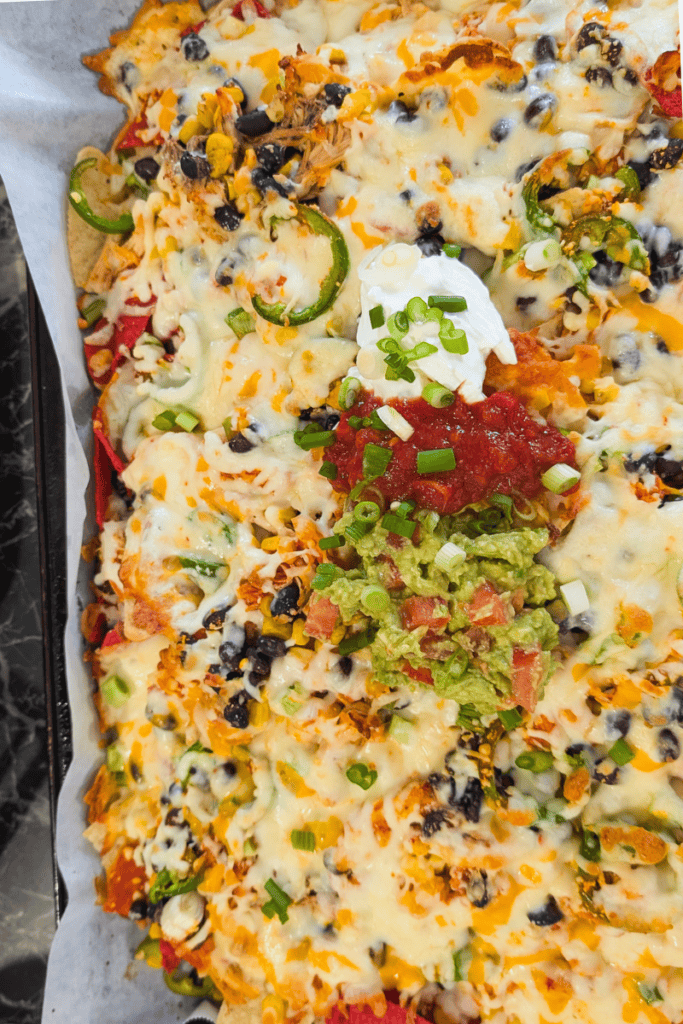 Delicious buffalo chicken nachos topped with cheese, jalapeños, and fresh toppings. Perfect for game.