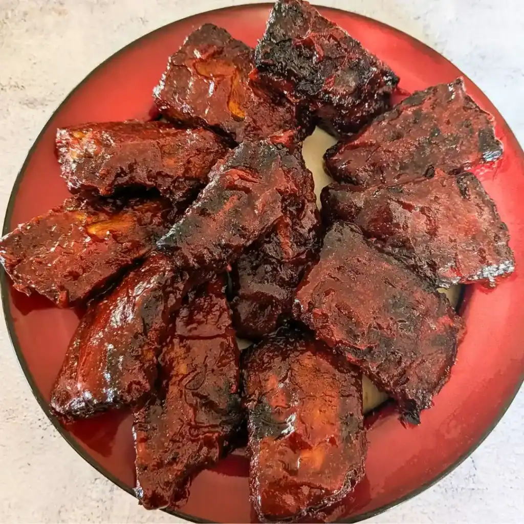 from about the recipe card image of sauced bbq ribs on red rimmed plate