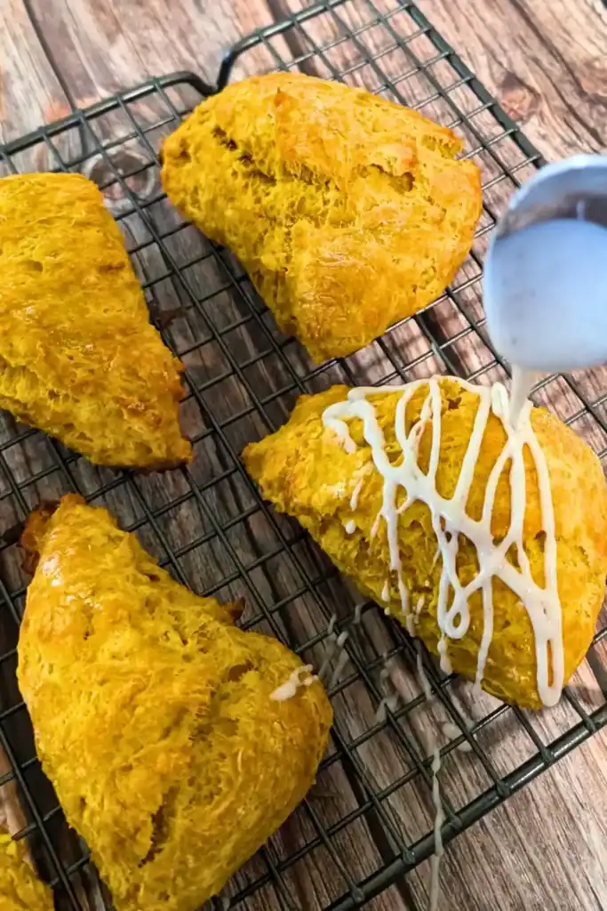 drizzling the pumpkin spice icing over the baked scones