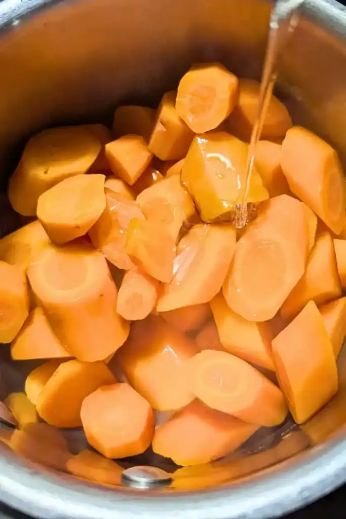 adding honey to cooked carrots