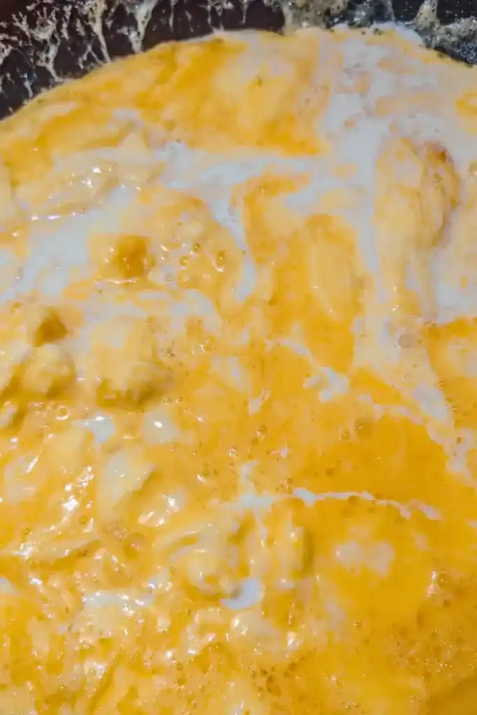adding heavy cream to partially cooked scrambled eggs
