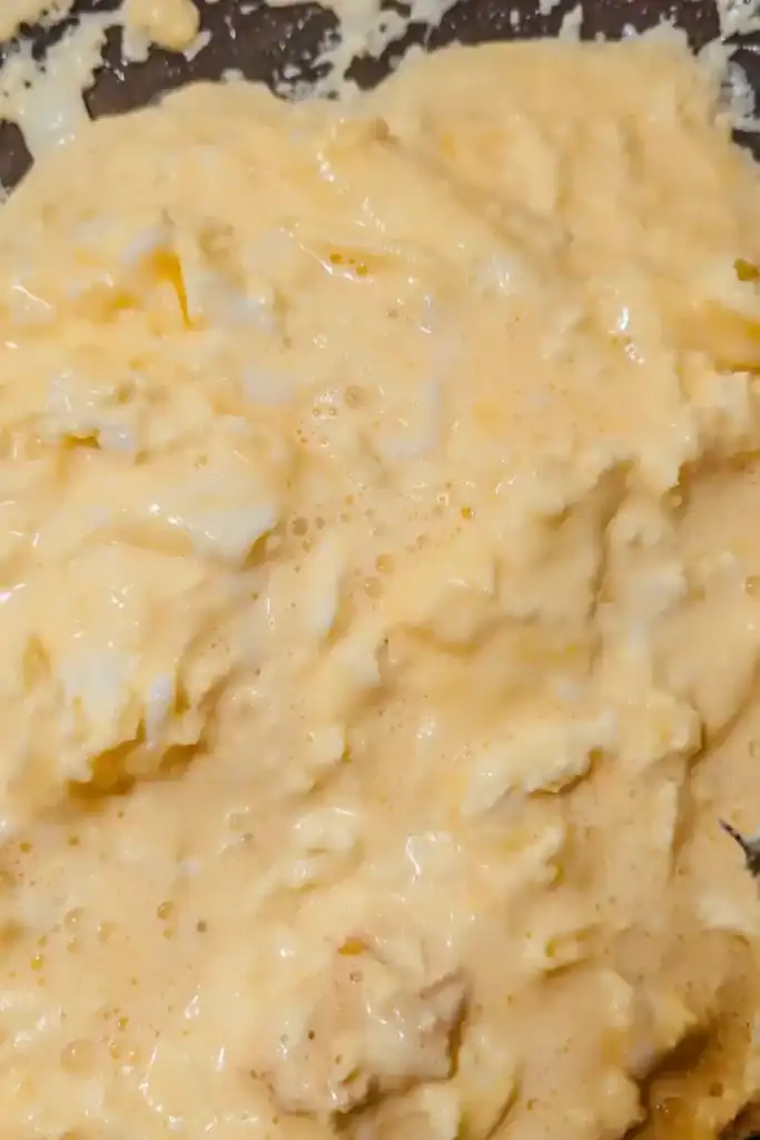 mixed eggs and cream for scrambled eggs in frying pan