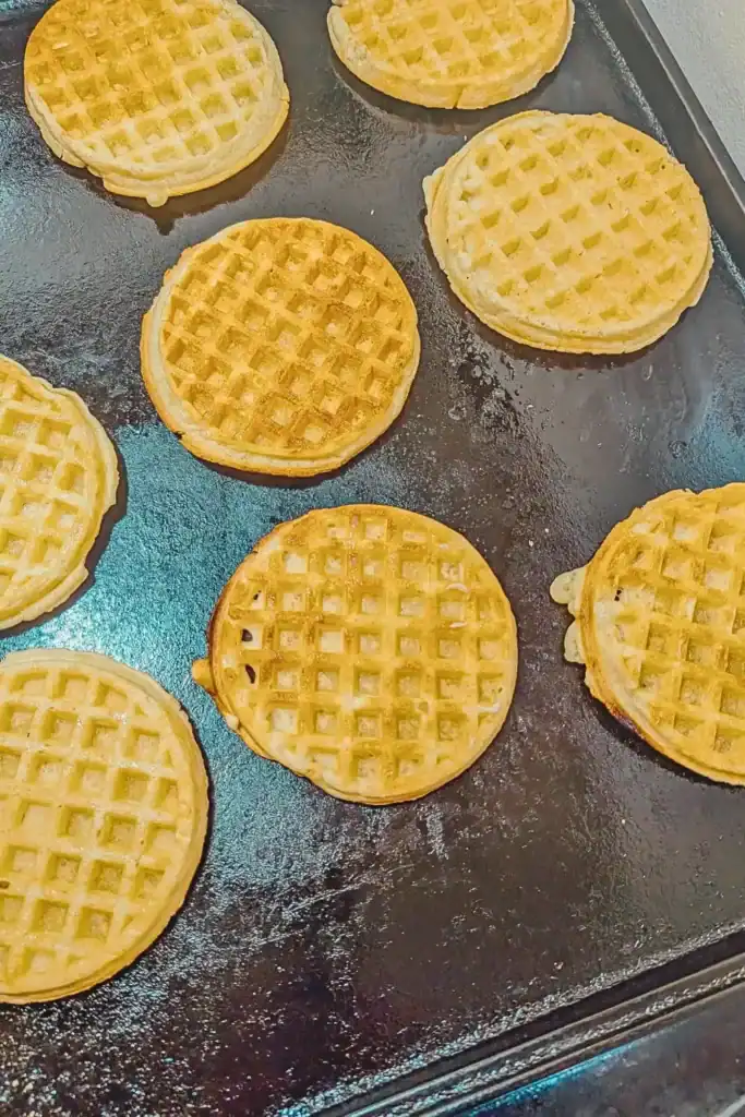 adding frozen waffles with butter onto baking sheet