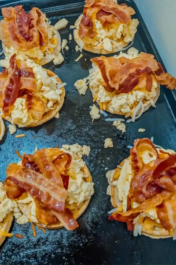 topping with crisp bacon on scrambled egg for waffle breakfast sandwich