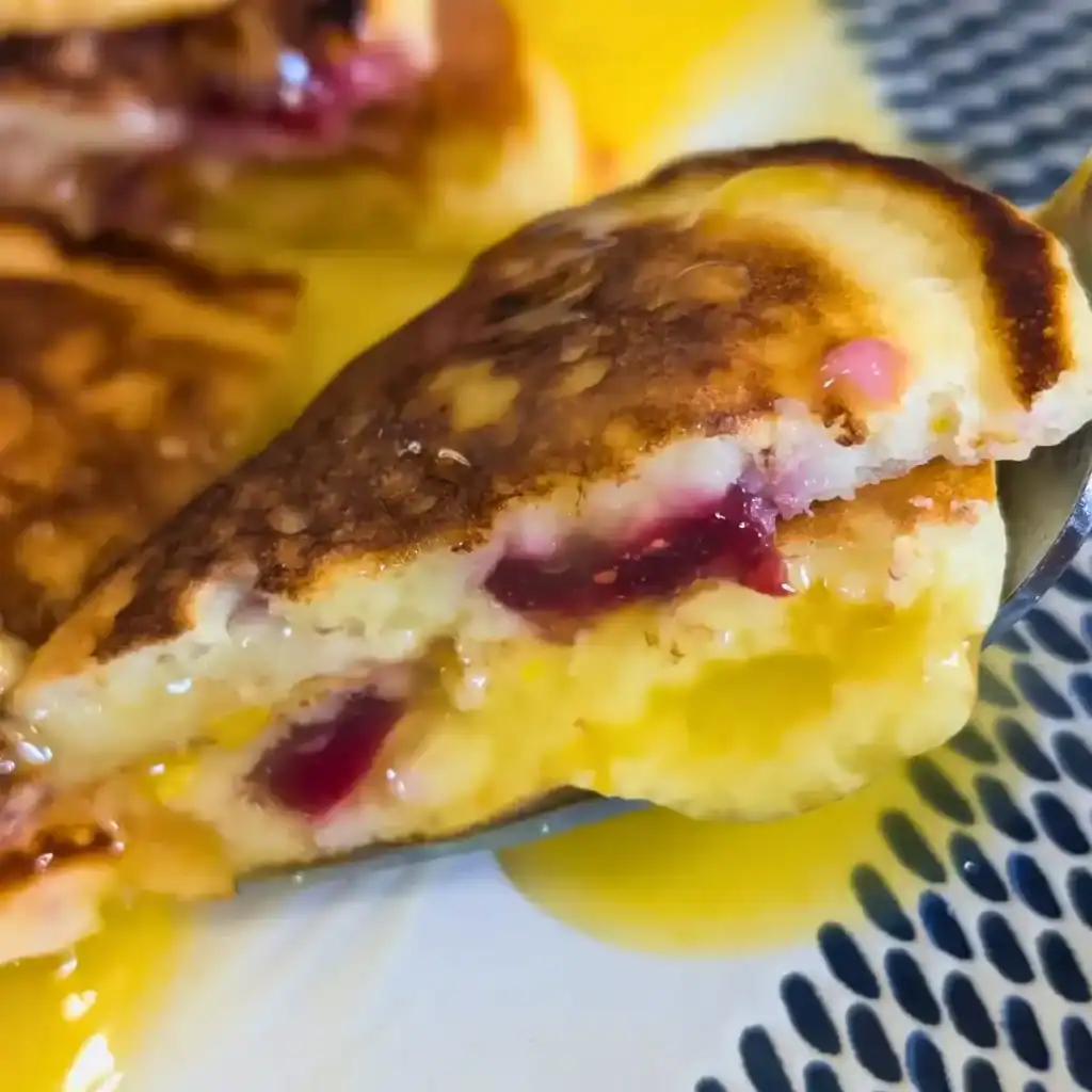 featured image of orange cranberry pancakes with orange sauce