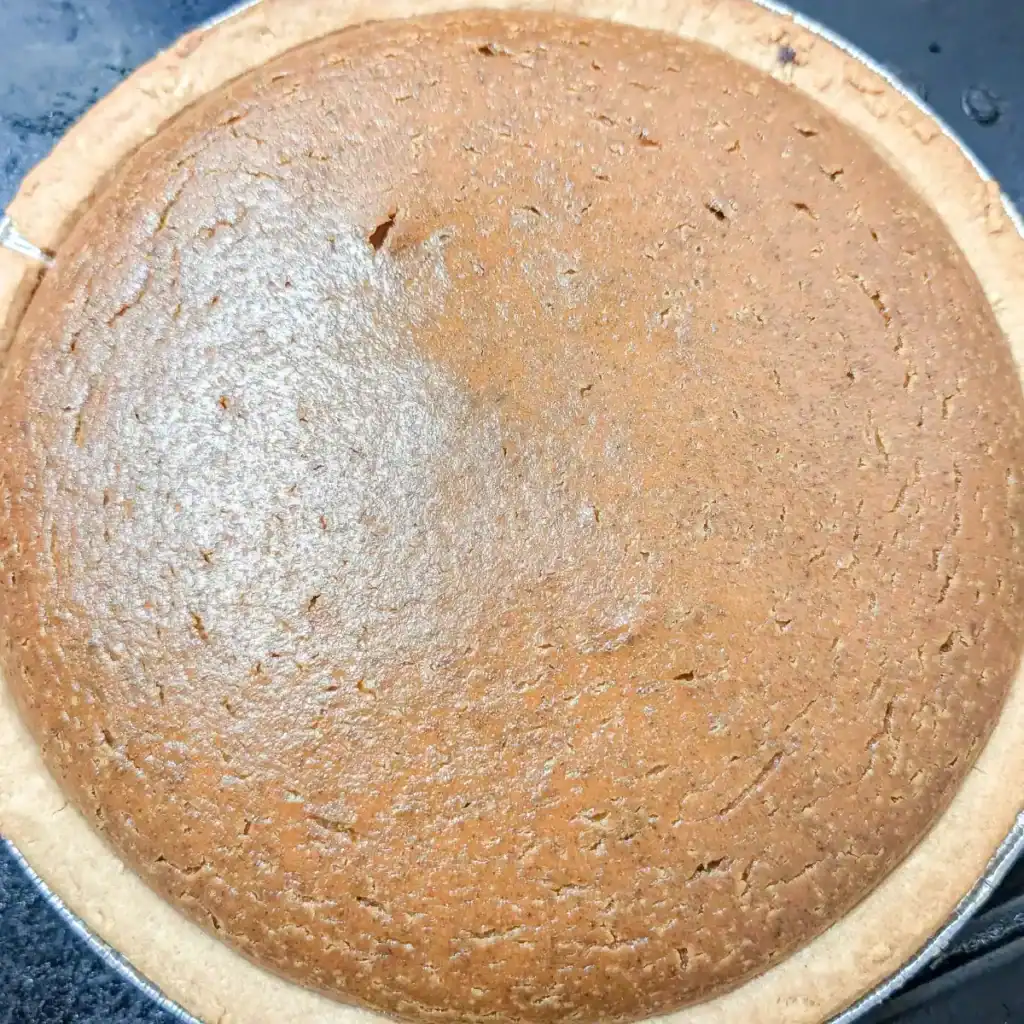 Whole baked pumpkin pie with homemade pie filling made from canned pumpkin puree