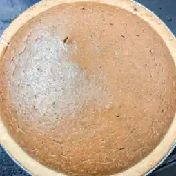Whole baked pumpkin pie with homemade pie filling made from canned pumpkin puree