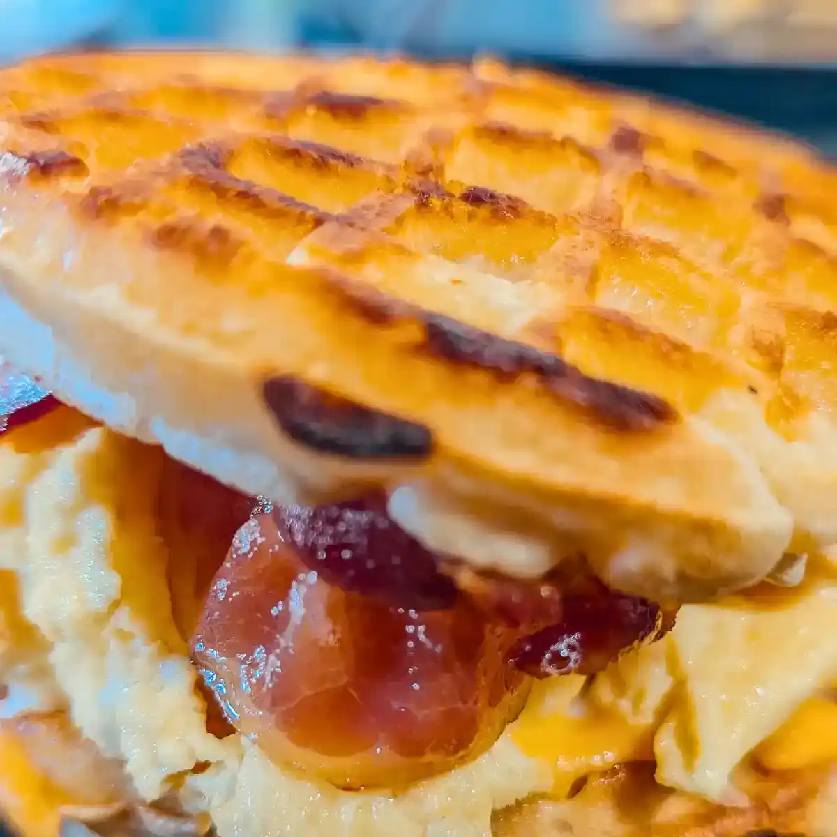 close up side view of grilled cheese waffle bacon egg sandwich