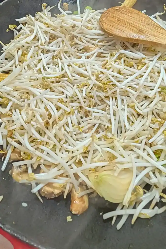 adding the bean sprouts to the chicken chop suey