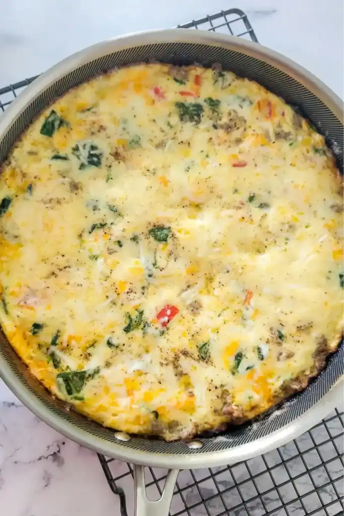 the finished baked frittata cooling on wire rack on white marble