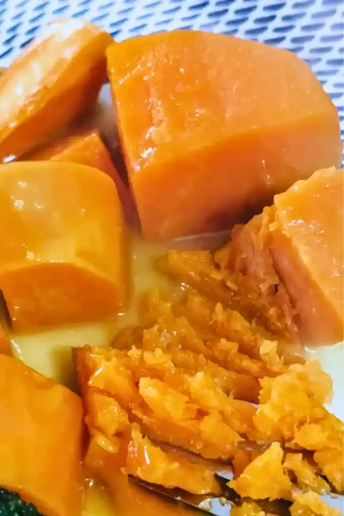 chunks of orange sauced sweet potato on blue and white plate