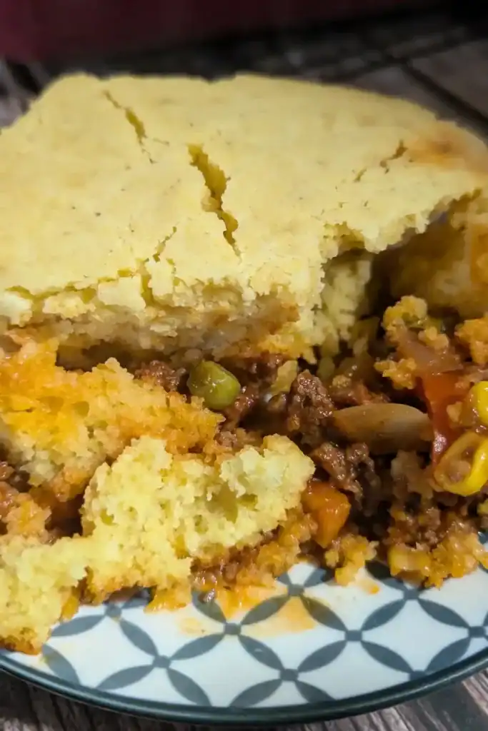 the cornbread casserole served on a blue and white plate