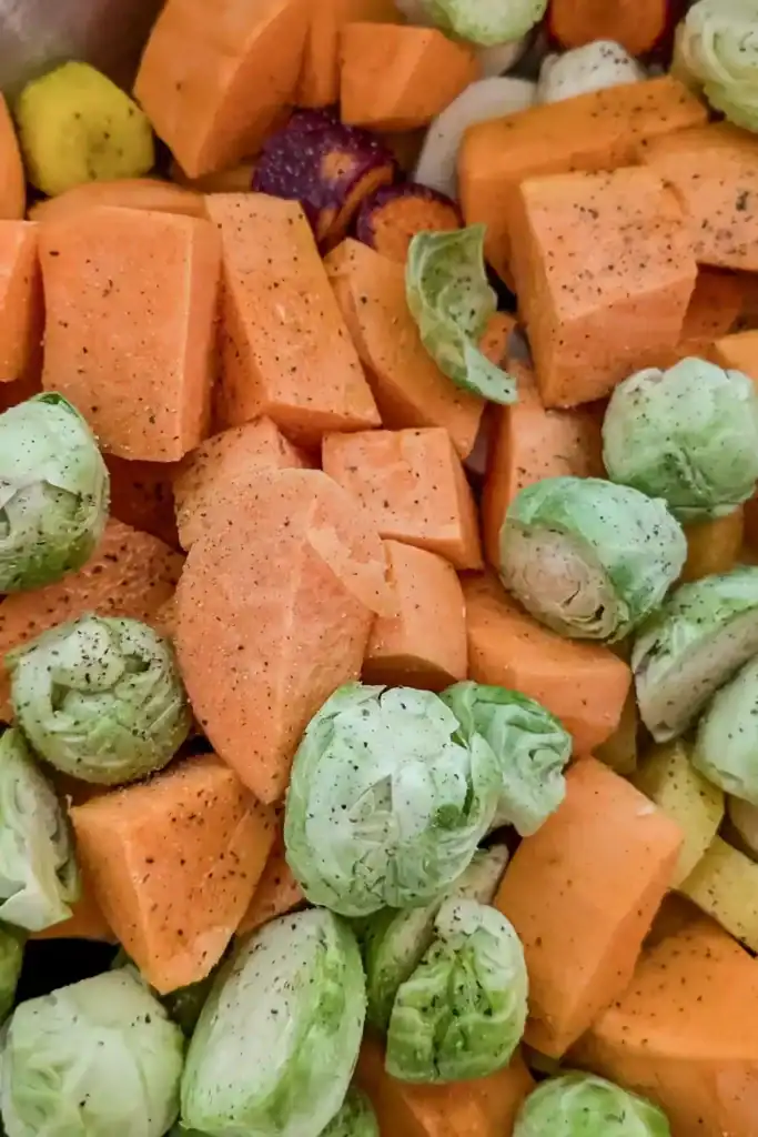 adding pepper salt and olive oil to vegetables in bowl