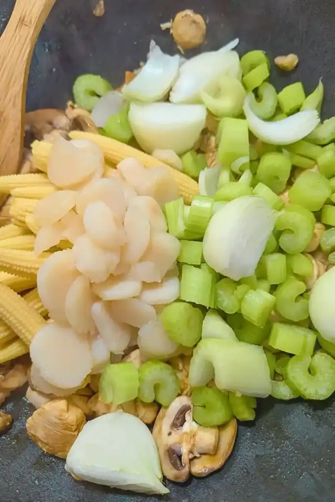 adding celery, onion and sliced water chestnuts to the chicken chop suey