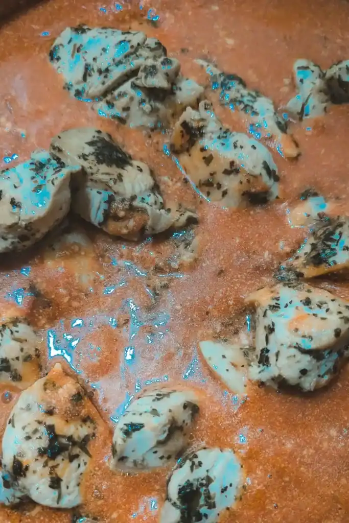 returning cooked chicken chunks to pan
