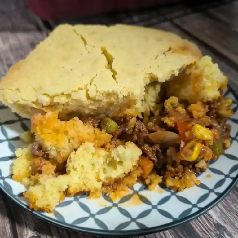Another angle of the cornbread casserole served on a blue and white patterned plate