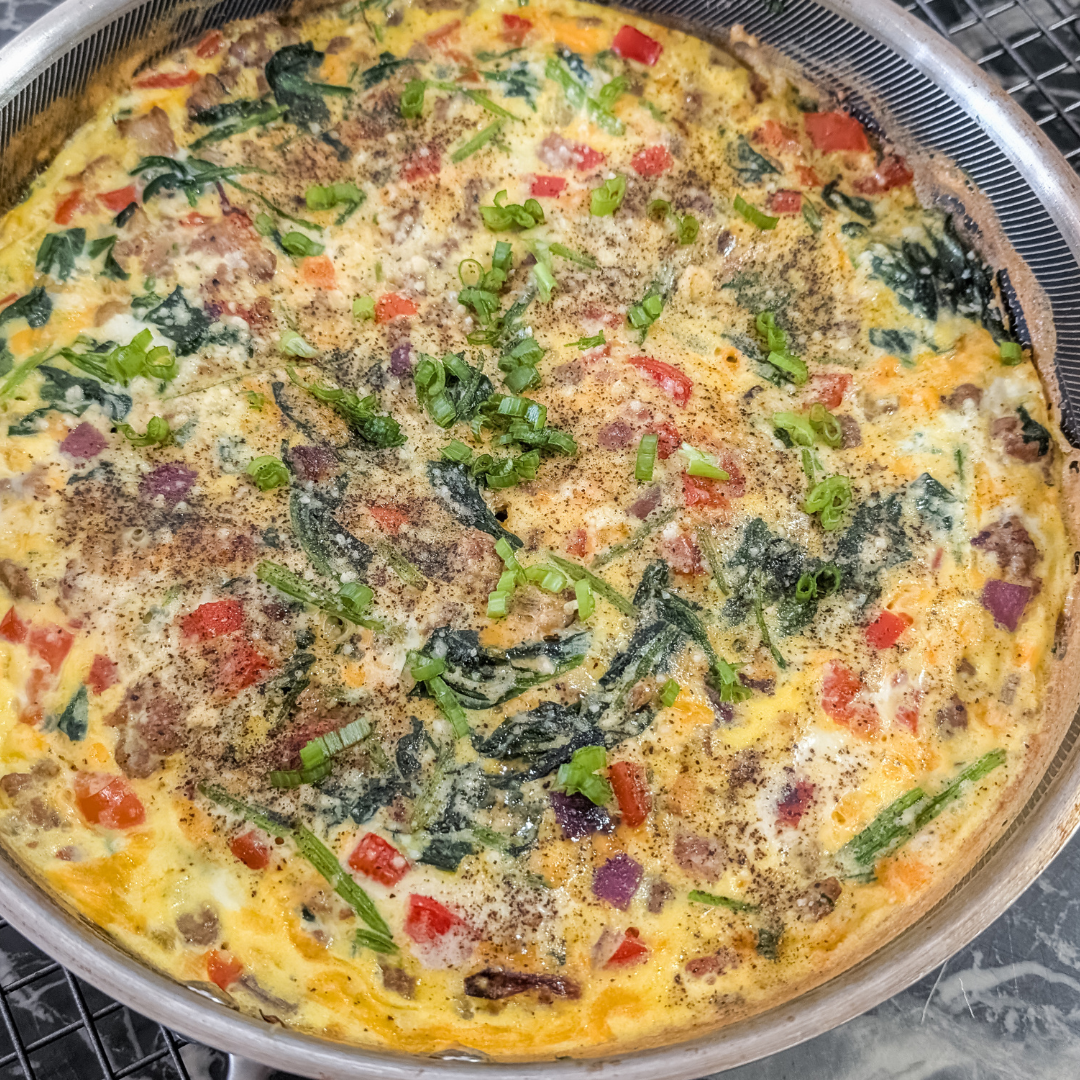 Delicious sausage and spinach frittata with fresh herbs and vegetables.