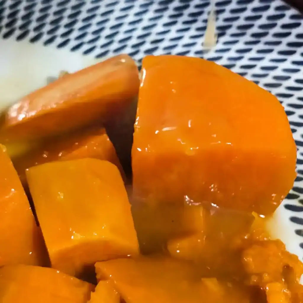 drizzling orange sauce on sweet potatoes