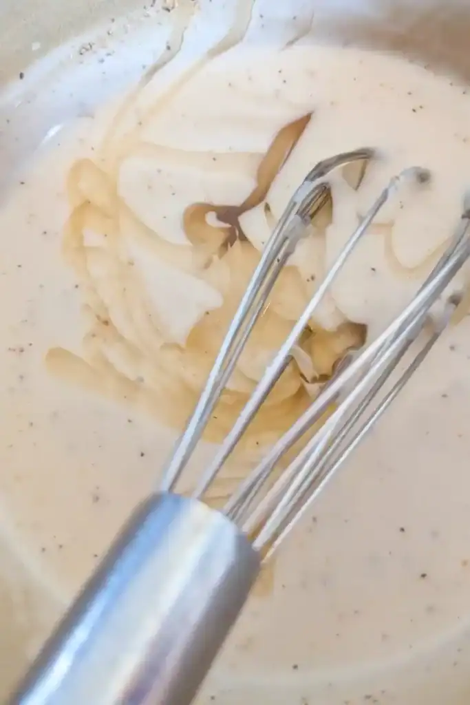 whisking in honey to the salad dressing