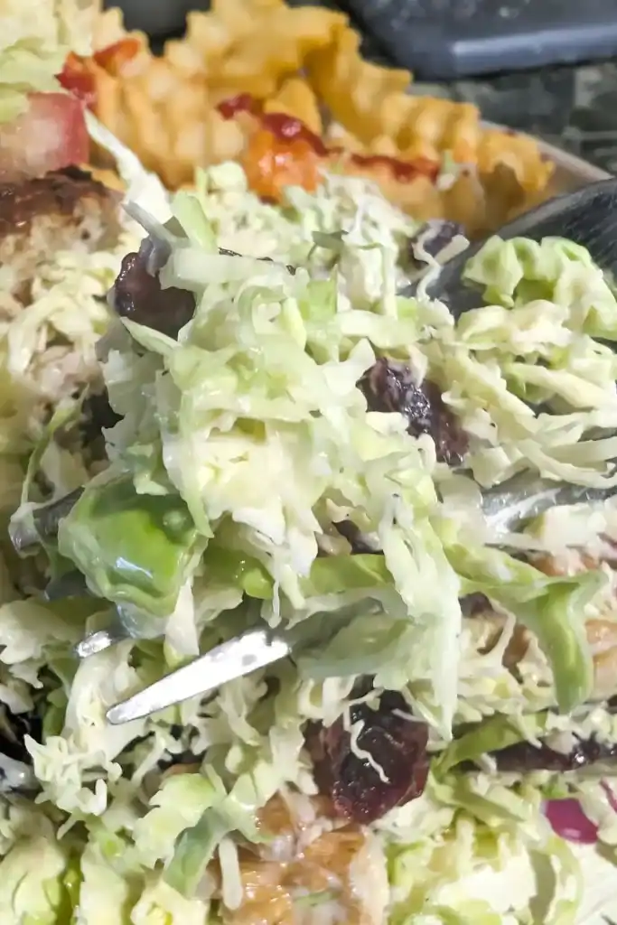 another angle of the brussels sprouts salad on plate being forked up