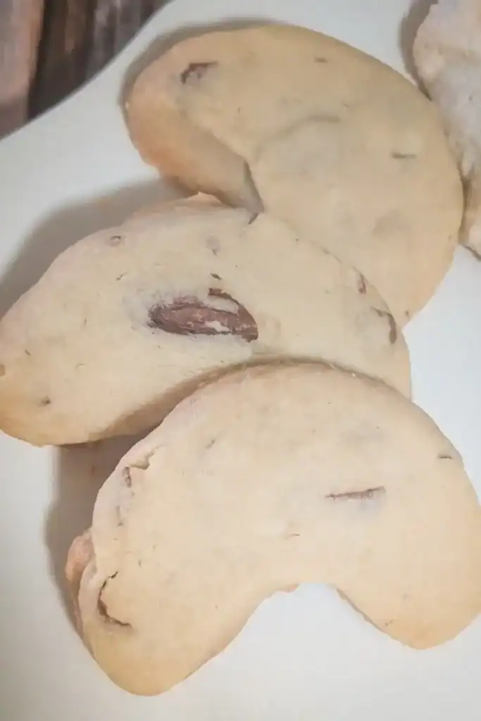three almond shortbread crescent cookies lined on cookie plate
