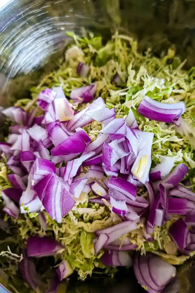 diced red onion and brussels sprouts shaved in bowl