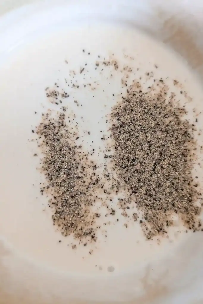 adding sour cream and black pepper to the salad dressing
