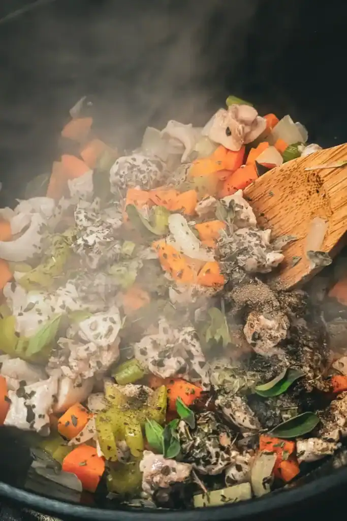 adding herbs and spices to the chicken and mirepoix