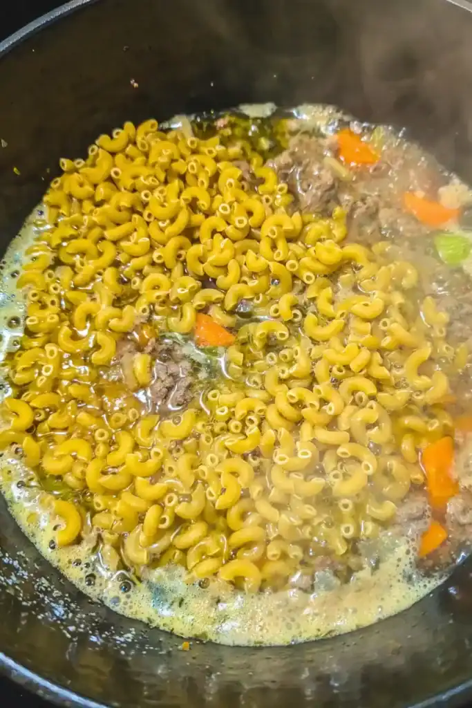 adding dry macaroni to the soup