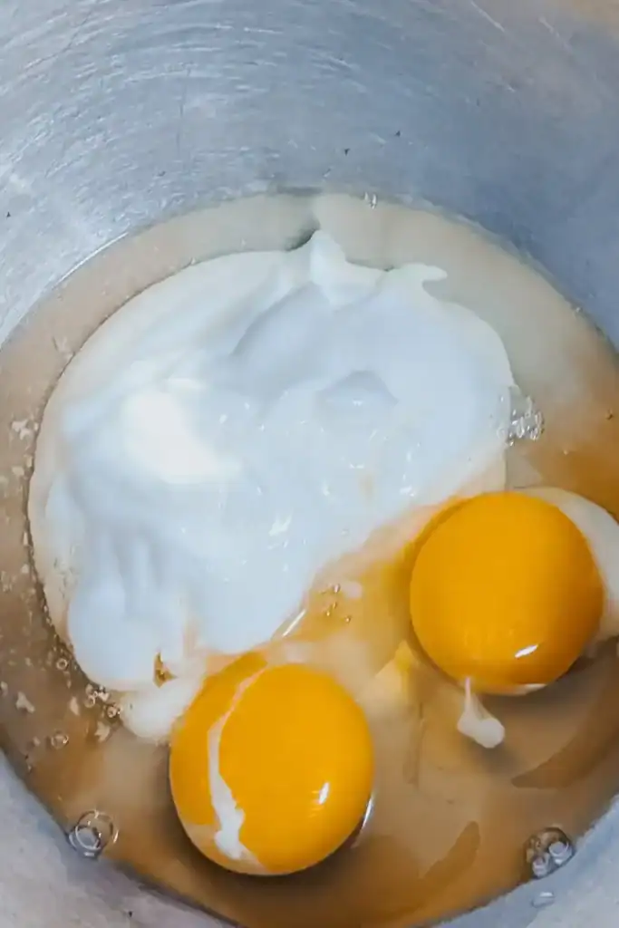adding sour cream and eggs to another bowl