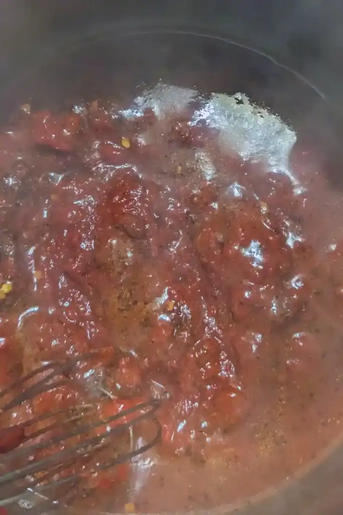 adding tomato paste to the sauce
