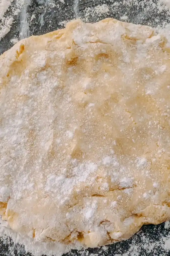 patting dough down on floured work surfac