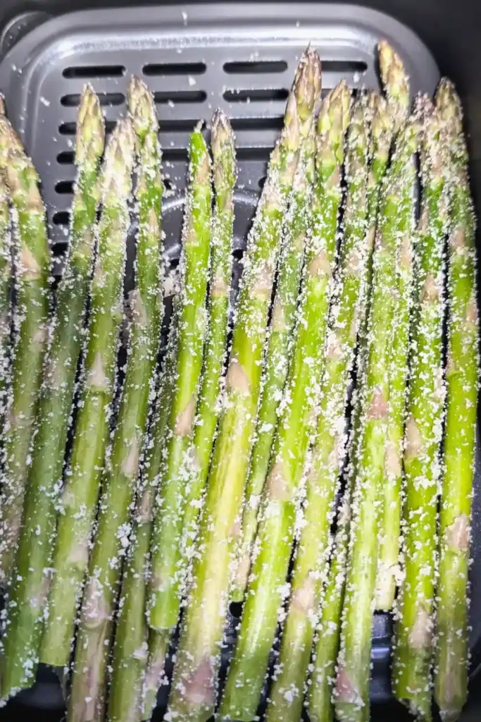 laying asparagus spears in air fryer basket