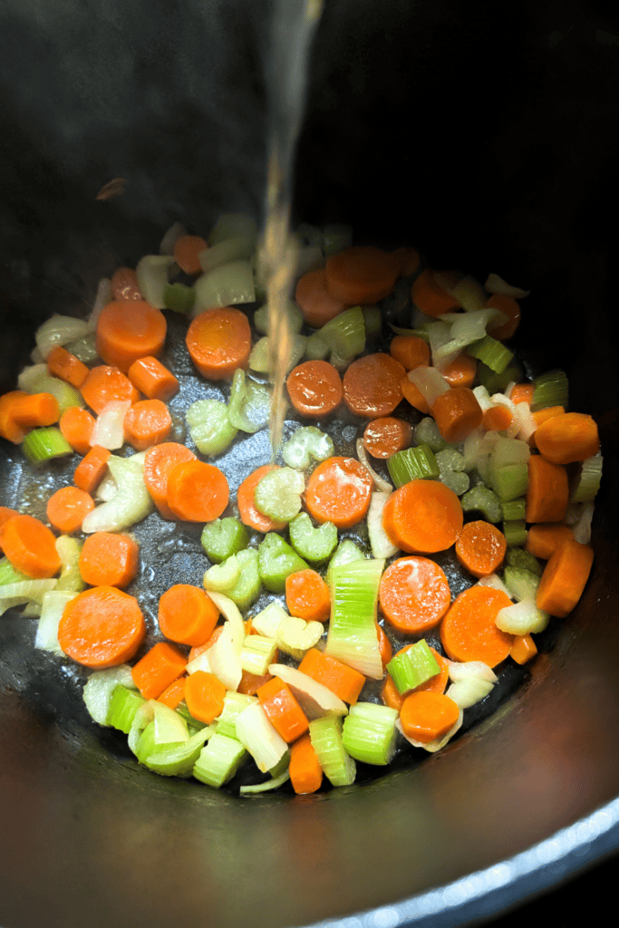 adding chicken stock to mirepoix