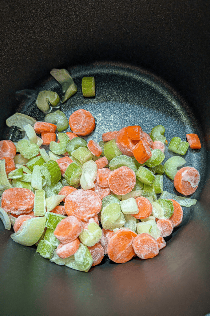 adding frozen mirepoix to soup pot
