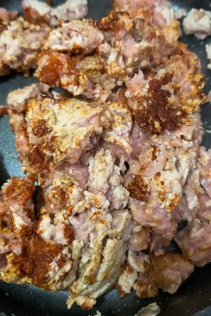 adding chili powder to the ground chicken