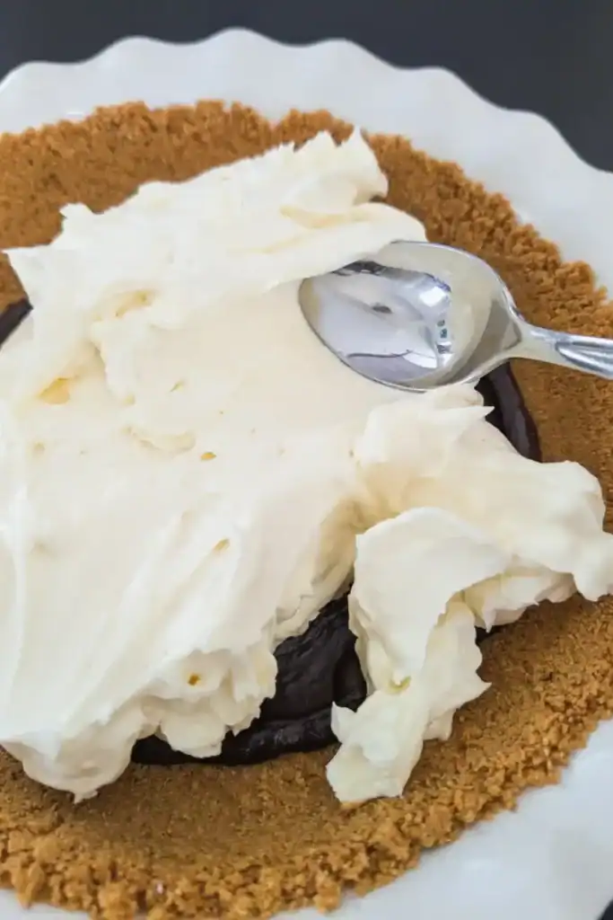 spreading cream cheese mixture on chocolate