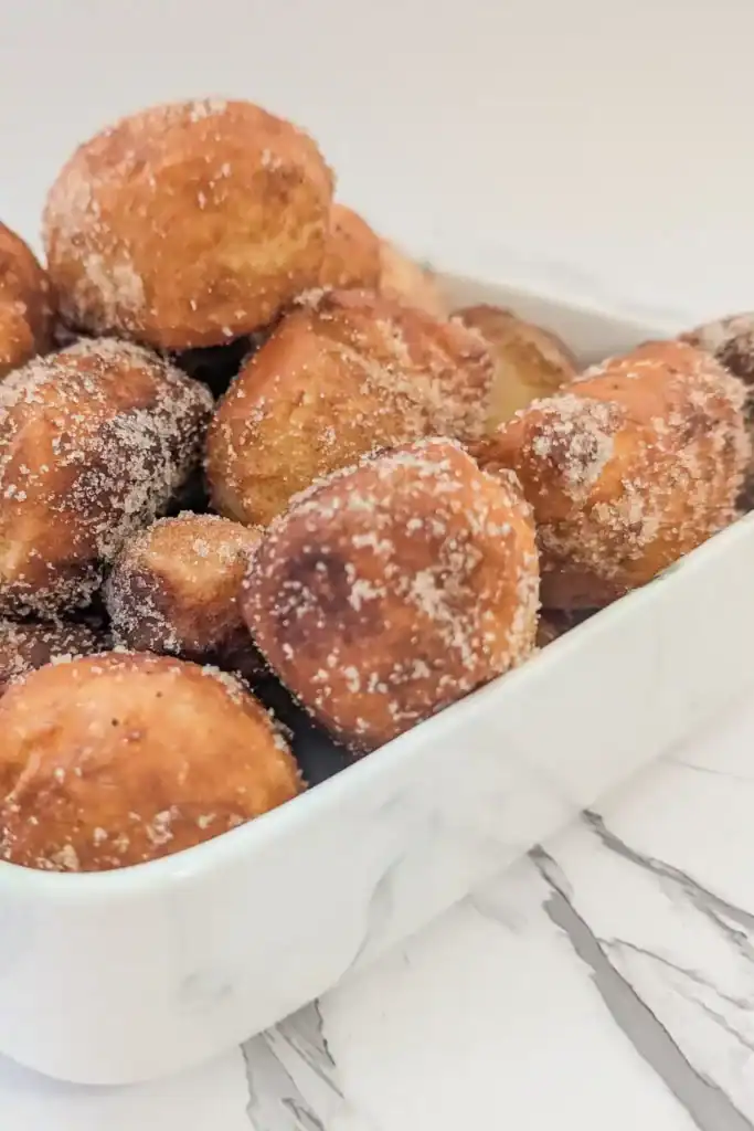 close up of a stack of chai sugared donut holes in dish