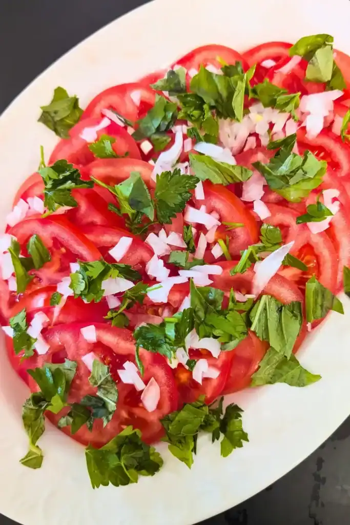 adding herbs to tomato and onion