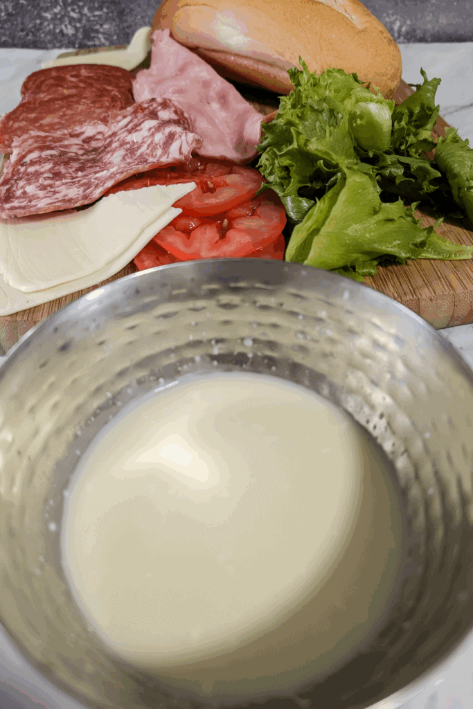 the finished sub sauce next to sandwich ingredients