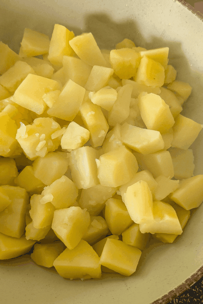 adding cooked potato to bowl