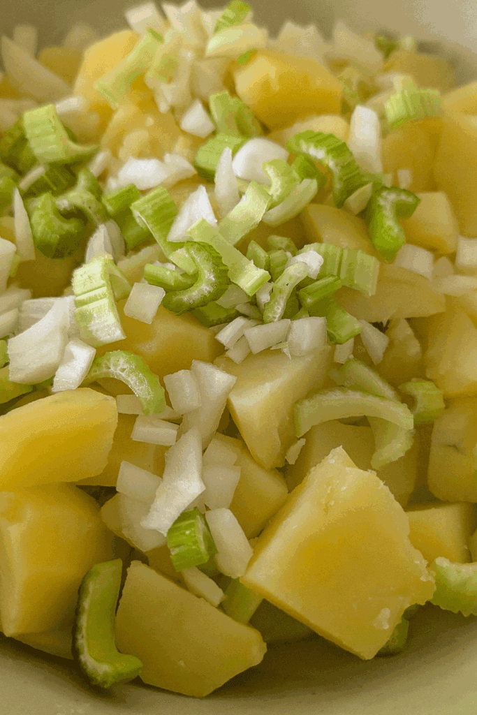 adding onion and celery to potato