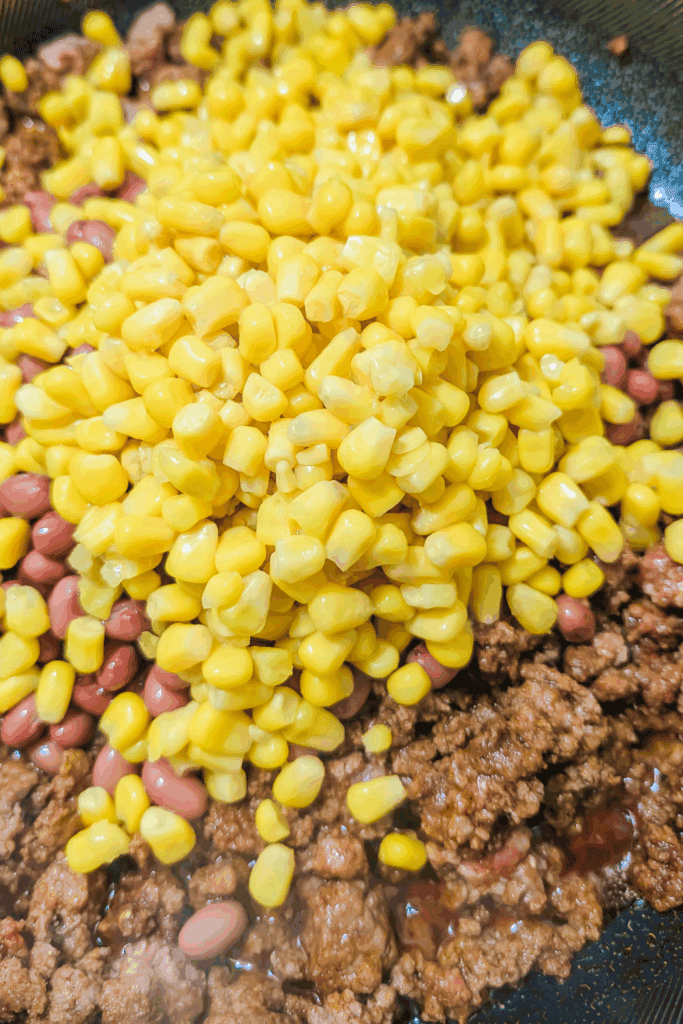 adding the corn to the chili