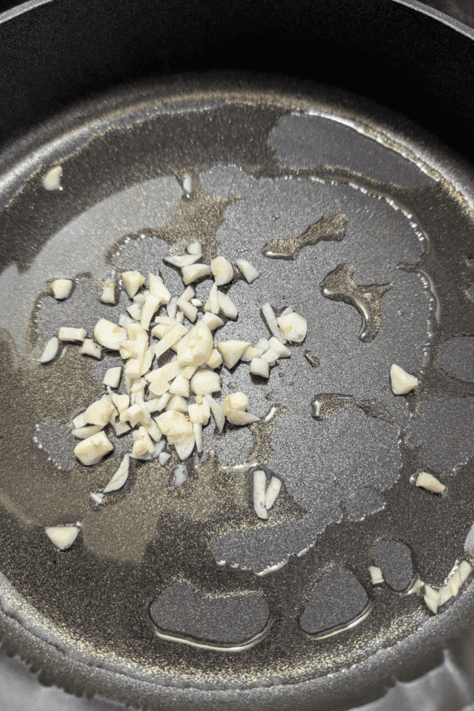 adding oil and garlic to skillet