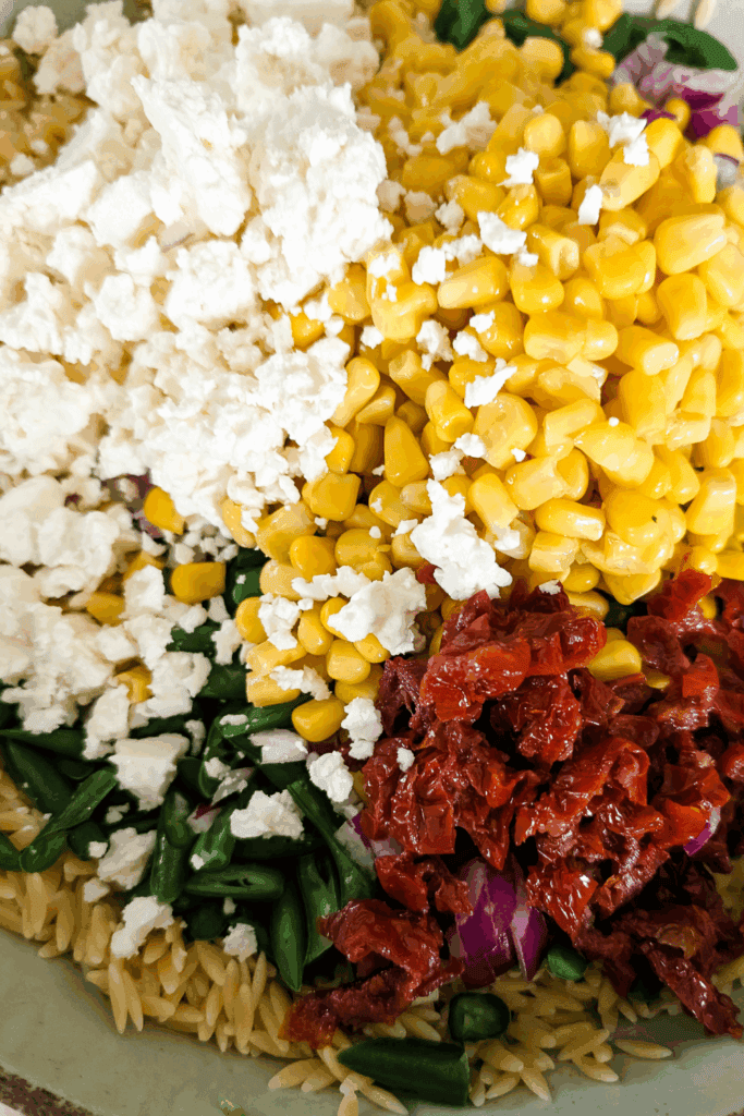 adding sun dried tomato and feta to bowl