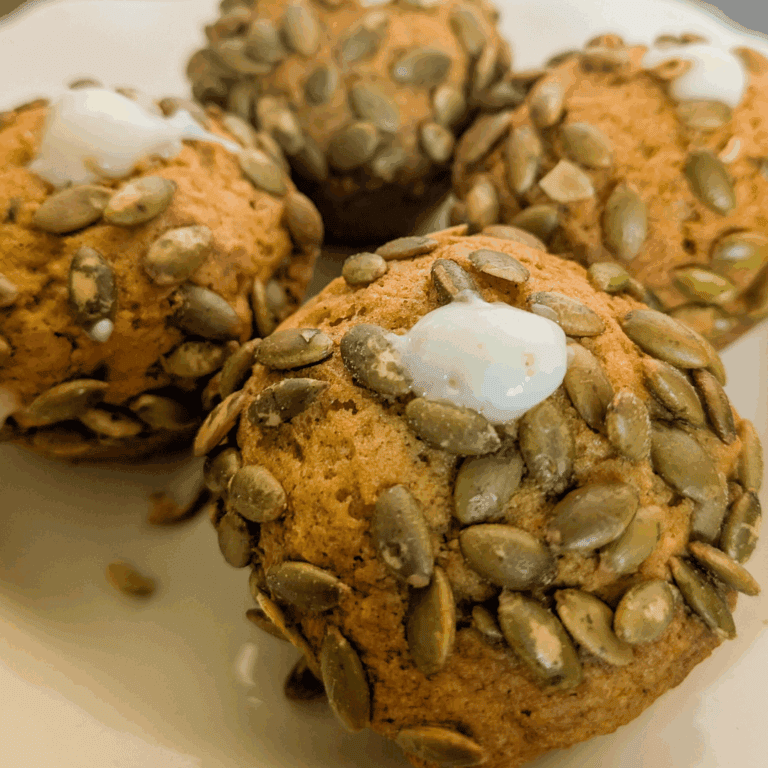 Pumpkin scones with pumpkin seeds and a dollop of cream, perfect for fall baking recipes.