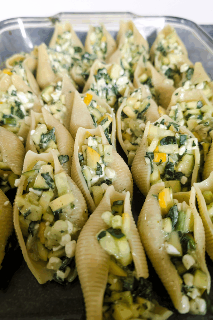 Stuffed pasta shells with vegetable filling on a baking sheet, perfect for savory dinner recipes.