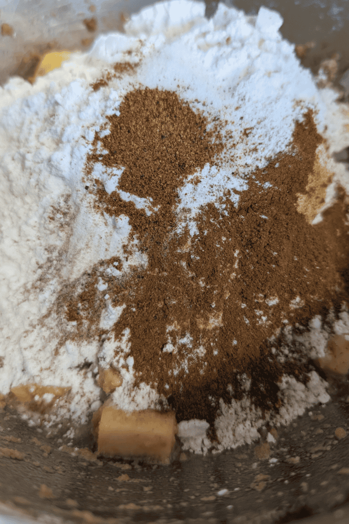 Close-up of cinnamon, cocoa powder, and flour in a mixing bowl.