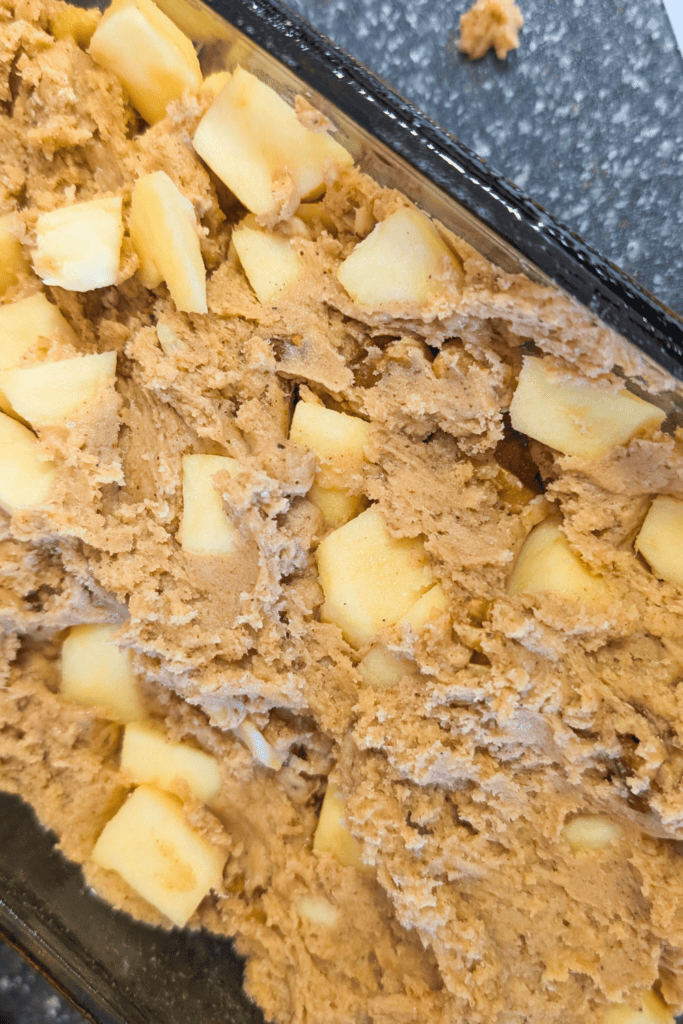 Delicious homemade cookie dough with chunks of fresh apples, perfect for baking or snacking.